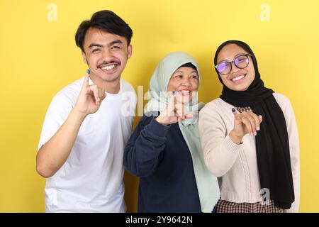Die drei indonesische Familie zeigte Tinta Pemilu, den Finger, nachdem sie für die Parlamentswahlen oder Pilkada gestimmt hatte Stockfoto