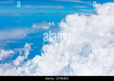 Luftaufnahme eines klaren blauen Himmels mit flauschigen weißen Wolken aus dem Flugzeugfenster. Weiche Wolken aus der Perspektive eines Flugzeugs im Flug Stockfoto