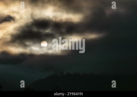 Sonne über einer Bergkette, die durch Morgenwolken und Nebel bricht, Leoben, Steiermark, Österreich, Europa Stockfoto