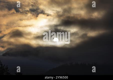 Sonne über einer Bergkette, die durch Morgenwolken und Nebel bricht, Leoben, Steiermark, Österreich, Europa Stockfoto