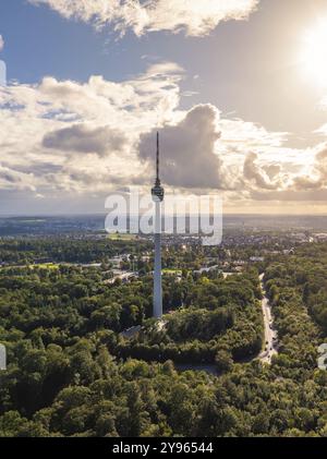 Der Fernsehturm erhebt sich über einem großen Waldgebiet unter teilweise bewölktem Himmel im Sonnenlicht, Stuttgart, Deutschland, Europa Stockfoto