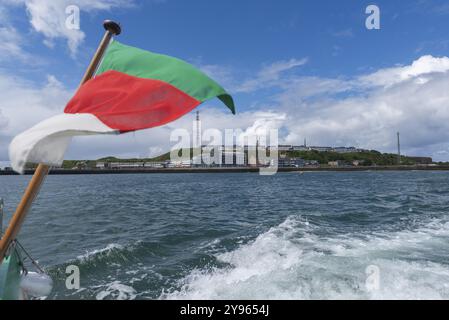 Blick von Südosten zu den Hafenanlagen, Unterland und Oberland, vor der Küste gelegene Insel Helgoland, Helgolandflagge, Funkturm, blauer Himmel, Nordsee, Pin Stockfoto