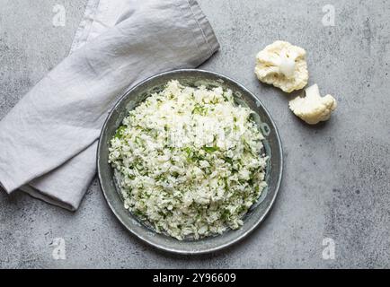 Roher Blumenkohl-Reis oder Couscous mit Dill auf dem Teller, gesunde kohlenhydratarme pflanzliche Beilage für Keto-Diät und gesunde kalorienarme Ernährung auf Stockfoto