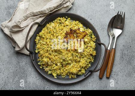 Gebratener Blumenkohl-Reis oder Couscous mit Dill auf dem Teller, gesunde kohlenhydratarme Gemüse-Beilage für Keto-Diät und gesunde kalorienarme Ernährung Stockfoto