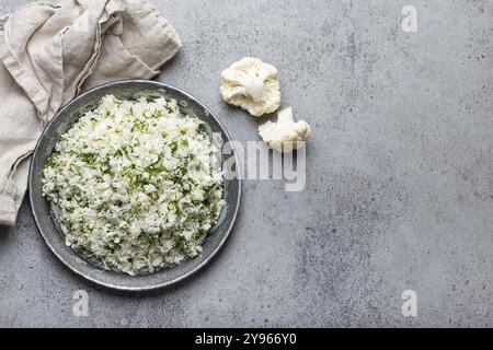 Roher Blumenkohl-Reis oder Couscous mit Dill auf dem Teller, gesunde kohlenhydratarme pflanzliche Beilage für Keto-Diät und gesunde kalorienarme Ernährung auf Stockfoto