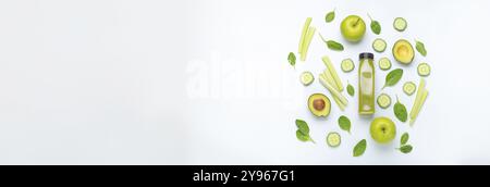 Flasche grüner Smoothie umgeben von grünem Obst und Gemüse: Äpfel, Avocado, Spinat, Sellerie, Gurke auf weißem einfachen Hintergrund von oben. Matrize Stockfoto