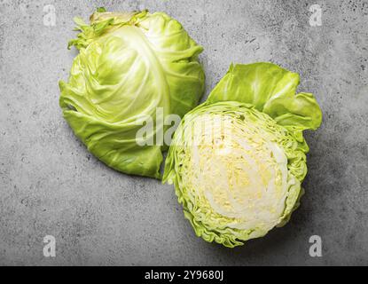 Frischer roher Bio-Bauernkohl in der Hälfte auf grauem rustikalem Steinhintergrund von oben Ansicht, gesunder Kohl in ausgewogener Ernährung und Kochkonzept, Food p Stockfoto