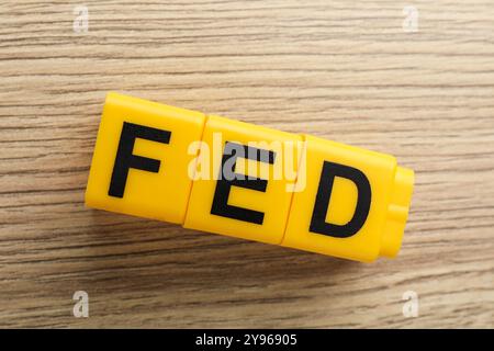 Würfel mit den Buchstaben Fed (Federal Reserve System) auf Holztisch, Draufsicht Stockfoto