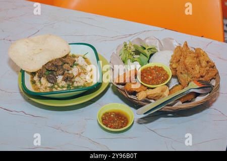 Lalapan Telur und Rawon serviert mit Sambal auf weißem Tisch | authentisches traditionelles indonesisches Essen Stockfoto