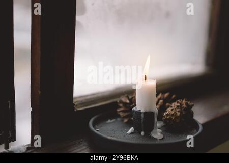 Eine warme Kerzenflamme flackert vor einem weichen Hintergrund Stockfoto