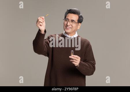 Senior-Mann mit Cordyceps sinensis Stockfoto