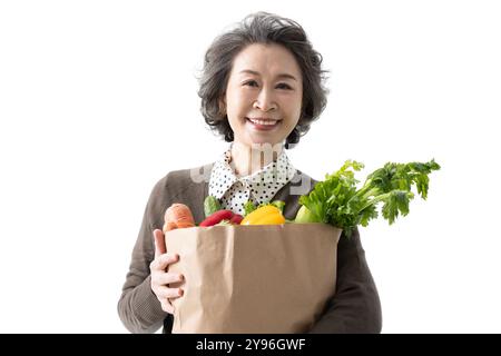 Seniorin, die Lebensmittel hält Stockfoto