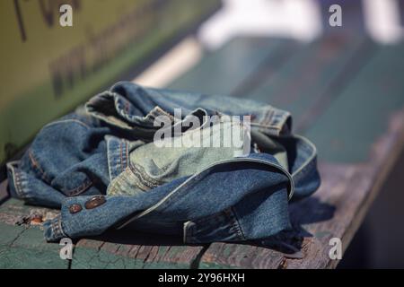 Jean Jacket auf einer Bank zurückgelassen Stockfoto