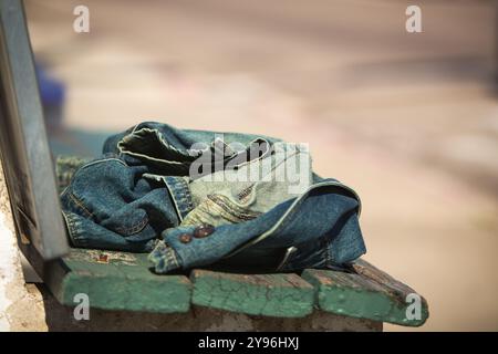 Jean Jacket ist allein auf einer Bank Stockfoto