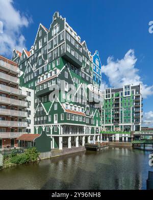 Zaandam, Niederlande. 9. Juni 2024. Farbenfrohes Inntel Hotel in Zaandam, gestapelte traditionelle Zaanse Häuser in Grün und Blau und Kanal davor. 2 Stockfoto