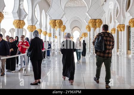 Die Leute besuchen die Scheich-Zayed-Moschee. Traditionell gekleidete Touristenfrauen in schwarzer Burka besuchen die große Moschee von Scheich Zayed in Abu Dhabi, Unit Stockfoto