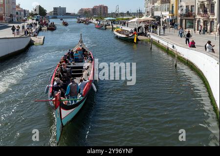 Aveiro, Portugal - 11. September 2024 : Touristen genießen eine Bootsfahrt entlang der bezaubernden Kanäle einer lebhaften Küstenstadt. Stockfoto