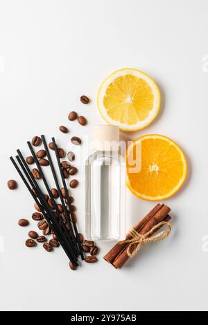 Aromatische Darstellung von Zitrusfrüchten, Kaffeebohnen, Zimtstangen und Diffusor auf einer sauberen weißen Oberfläche Stockfoto