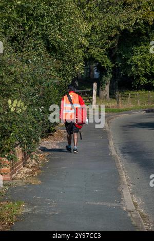 Der Postbote der Royal Mail läuft um. Stockfoto