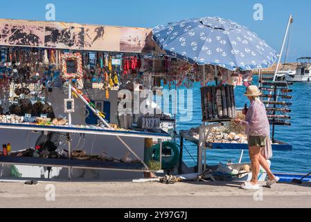 Souvenirladen Griechenland, Blick auf eine weibliche Touristenin, die einen schwimmenden Souvenirladen in der Altstadt von Venedig Hafen von Chania (Hania), Kreta Griechenland ansieht Stockfoto