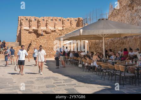 Kreta Sommer, Blick auf Leute, die an Tischen im Hania Sailing Club Cafe sitzen, das sich innerhalb der venezianischen Hafenmauern in Chania (Hania), Kreta, Griechenland befindet Stockfoto