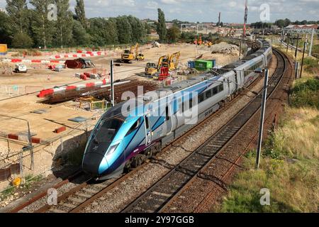 TransPennine Express 'Nova 1' Zweimode-Klasse 802 nähert sich dem Bahnhof York und passiert das Entwicklungsgelände York Central. Stockfoto