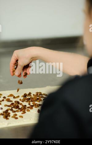 Nahaufnahme von Bäckerhänden, Bäckerei und Konditorei. Professioneller Konditor, der in einer Bäckerei arbeitet. Stockfoto