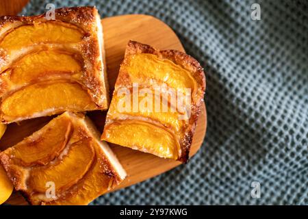 Ein Dessert aus geschnittenen Pfirsichen ist auf einem hölzernen Schneidebrett. Das Dessert ist mit Zucker bedeckt und sieht köstlich aus. Stockfoto