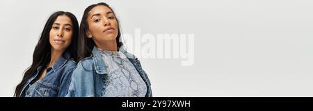 Eine junge Frau in modischen Jeansjacken nimmt mit ihrem Zwillingsbruder einen reflektierenden Moment ein. Stockfoto