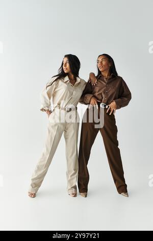 Zwei modische junge Frauen präsentieren trendige Outfits mit Selbstbewusstsein und Ausgewogenheit. Stockfoto