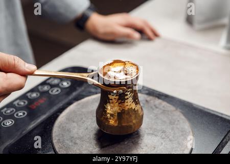 Zubereitung von türkischem Kaffee in traditionellem Heavy auf modernem Herd Stockfoto