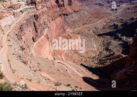 Ein atemberaubender Panoramablick auf den gewundenen Shafer Trail im Canyonlands National Park, Utah. Ein Auto fährt auf der unbefestigten Straße mit dramatischen Klippen. Stockfoto