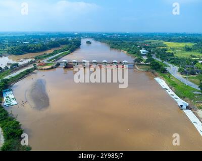 Aus der Vogelperspektive auf die Schleusen des Damms mit schnellem Wasserfluss in der Regenzeit. Stauwasser wird freigesetzt, Überkapazität nach starkem Regen. Stockfoto