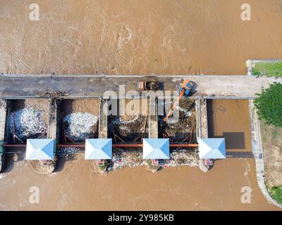 Aus der Vogelperspektive auf die Schleusen des Damms mit schnellem Wasserfluss in der Regenzeit. Stauwasser wird freigesetzt, Überkapazität nach starkem Regen. Stockfoto