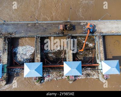 Aus der Vogelperspektive auf die Schleusen des Damms mit schnellem Wasserfluss in der Regenzeit. Stauwasser wird freigesetzt, Überkapazität nach starkem Regen. Stockfoto