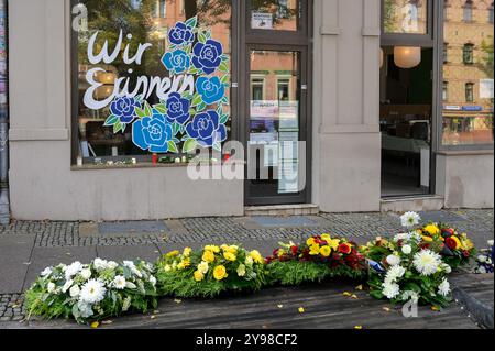 09. Oktober 2024, Sachsen-Anhalt, Halle (Saale): Die Opfer des Attentats vor fünf Jahren werden mit Blumenkränzen vor dem Dönerrestaurant geehrt. Die Stadt Halle erinnert an die Opfer des Terroranschlags 2019, als ein bewaffneter Angreifer versuchte, in die Synagoge einzubrechen. Als er versagte, erschoss und tötete er zwei Menschen auf der Straße und in einem Kebab-Laden. Foto: Heiko Rebsch/dpa Stockfoto