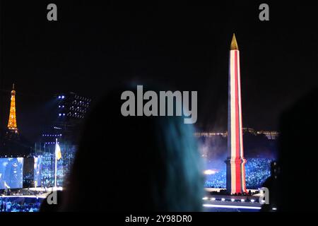 Der Luxor Obelisk (Obélisques de Louxor), der dem ägyptischen Pharao Ramses II gewidmet war. Er wurde mit einer spektakulären Klang-, Licht- und Lazershow beleuchtet. Außerdem ist der Eiffelturm ganz links zu sehen. Bei der Eröffnungszeremonie der Paralympischen Spiele 2024 am 28. August 2024 im Place de La Concorde, Paris, Frankreich. Stockfoto