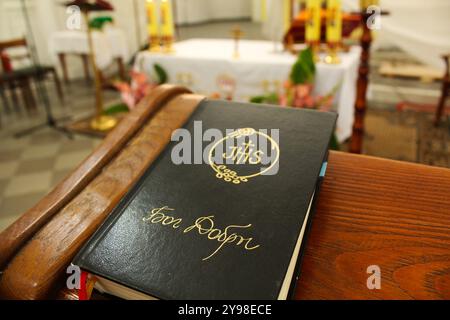 Bibelgebetbuch mit schwarzem Deckblatt in einer katholischen Kirche. Besuch der Kirche des Tempels. Stockfoto