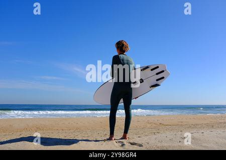 Junger Mann, der sich zum Surfen vorbereitet Stockfoto