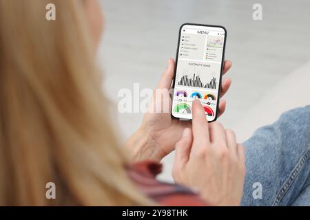 Frau, die intelligente Zählerwerte auf dem Handy überwacht, Nahaufnahme Stockfoto