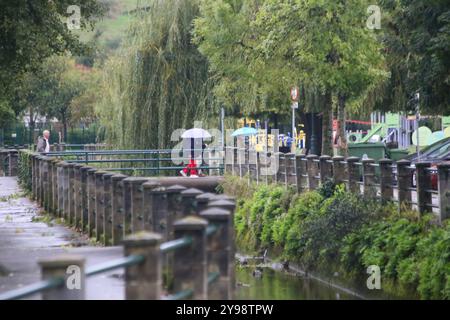 Noreña, Spanien, 9. Oktober 2024: Mehrere Menschen laufen mit einem Regenschirm während des Sturms, den Kirk am 9. Oktober 2024 in Noreña, Spanien trifft. Quelle: Alberto Brevers / Alamy Live News. Stockfoto