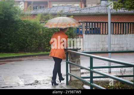 Noreña, Spanien, 9. Oktober 2024: Eine Frau läuft mit einem Regenschirm während des Sturms Kirk trifft Spanien am 9. Oktober 2024 in Noreña, Spanien. Quelle: Alberto Brevers / Alamy Live News. Stockfoto