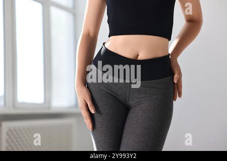 Frau trägt graue Sportleggings drinnen, Nahaufnahme Stockfoto