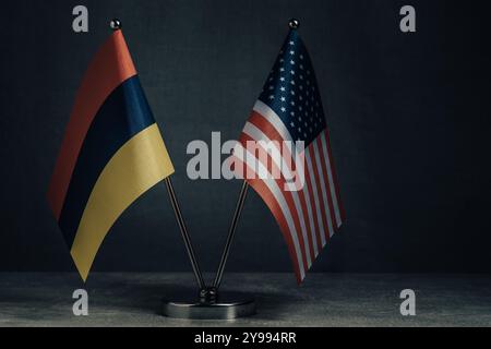 Tischflagge Vereinigte Staaten Amerika und Nationalflagge Armenien auf dunklem Hintergrund Stockfoto