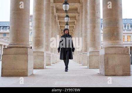 Pariser schöne Frau in Winterkleidung, die durch das Palais Royal France läuft Stockfoto