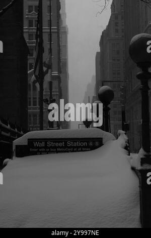 Die schneebedeckte Wall Street Station in einem ruhigen Wintersturm erobert New Yorks ikonisches Finanzviertel in friedlicher Stille. Stockfoto