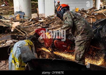 Elizabethton, Usa. Oktober 2024. Chad Bright, Stabsleiter der US Air National Guard, nutzt zusammen mit der 134th Civil Engineer Squadron, ein Schneidwerkzeug, um Metallrückstände nach den Überschwemmungen zu entfernen, die durch Hurrikan Helene am 7. Oktober 2024 in Elizabethton, Tennessee verursacht wurden. Quelle: SRA Xaviera Stevens/US Air Force/Alamy Live News Stockfoto