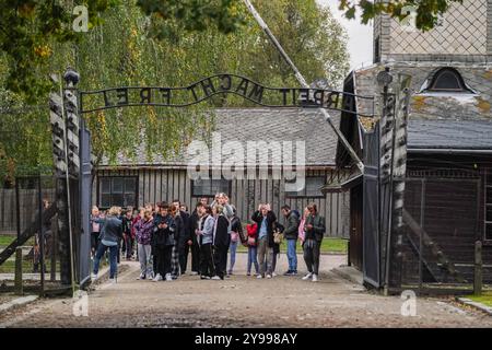 Oświęcim, Polen . 9. Oktober 2024 Besucher gehen an einem bewölkten Tag unter das Tor mit der deutschen Inschrift „Arbeit Macht frei“ im Konzentrationslager Auschwitz in Oświęcim, Polandcl. Auschwitz-Birkenau ist ein UNESCO-Weltkulturerbe, in dem mehr als eine Million Menschen ermordet wurden, darunter 960.000 Juden. Credit.Amer Ghazzal/Alamy Live News Stockfoto