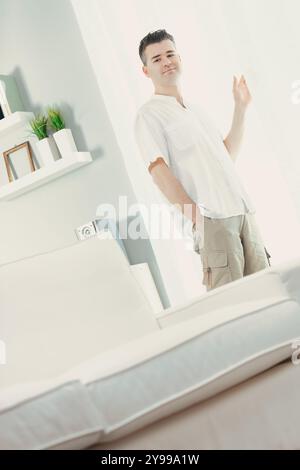 In einem hellen Wohnzimmer mit modernem Design, weißen Wänden, minimalistischen Möbeln und Pflanzen gibt es zwanglose Gesten. Der Raum ist einladend und erlebbar Stockfoto