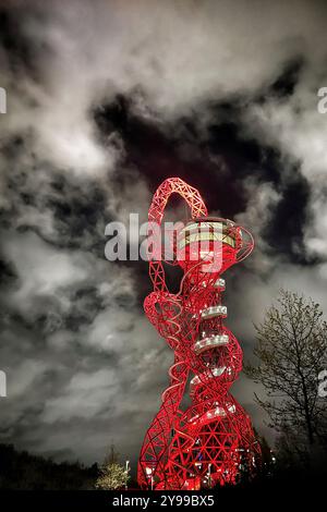 Der ArcelorMittal Orbit leuchtet nachts bei einem bewölkten Himmel im Queen Elizabeth Olympic Park in Stratford. London, Großbritannien Stockfoto